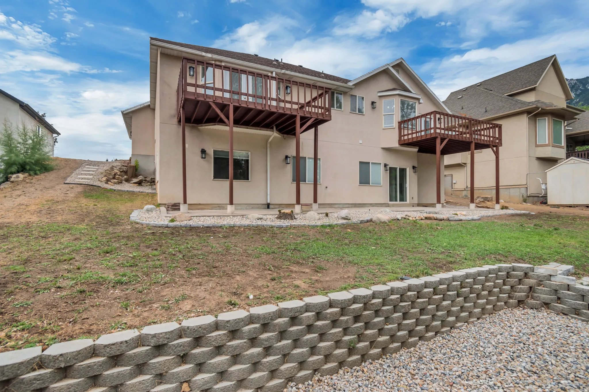 Back of house with a patio, stucco siding, a deck, and a yard