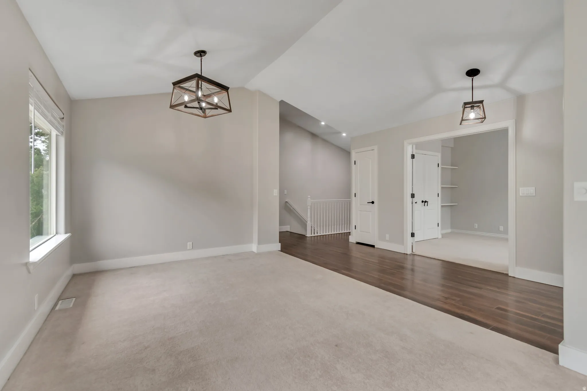 Unfurnished dining area with dark carpet, vaulted ceiling, a chandelier, and dark wood-style flooring