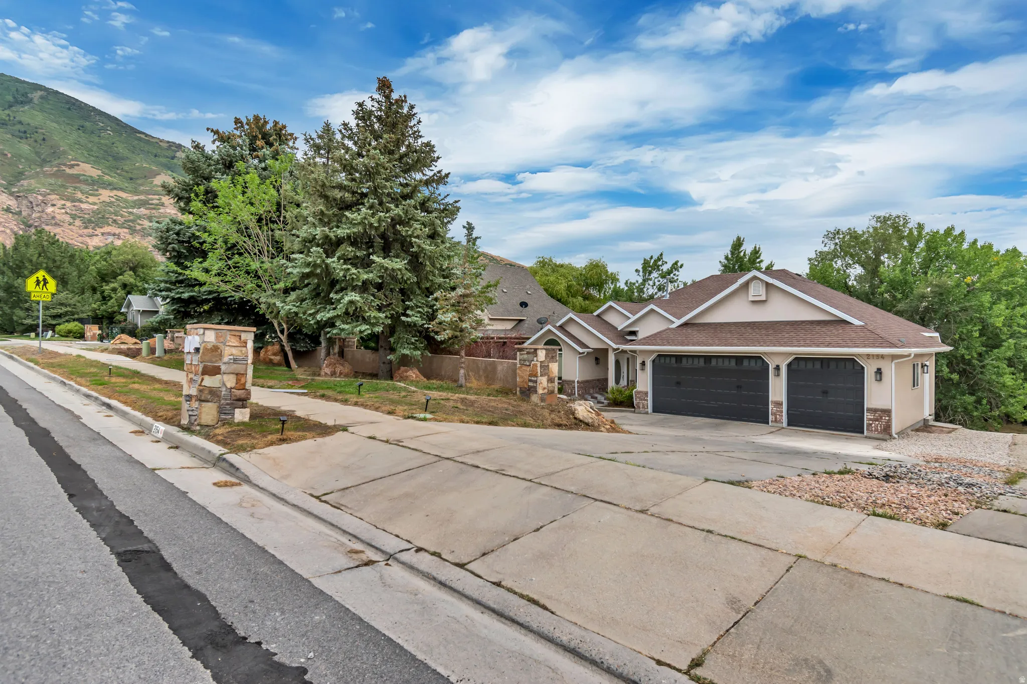 Craftsman inspired home featuring concrete driveway, an attached garage, stone siding, and stucco siding
