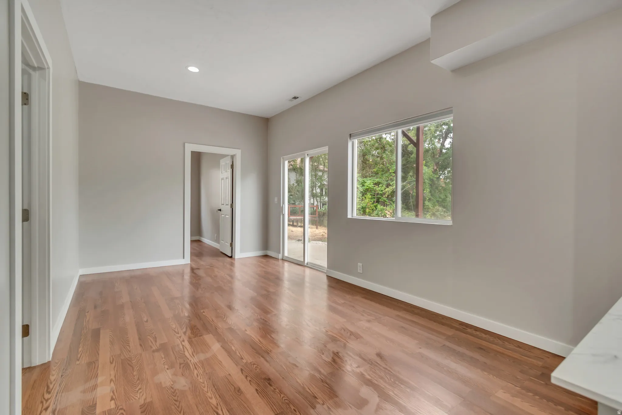 Unfurnished bedroom featuring access to outside, light wood-style flooring, and recessed lighting
