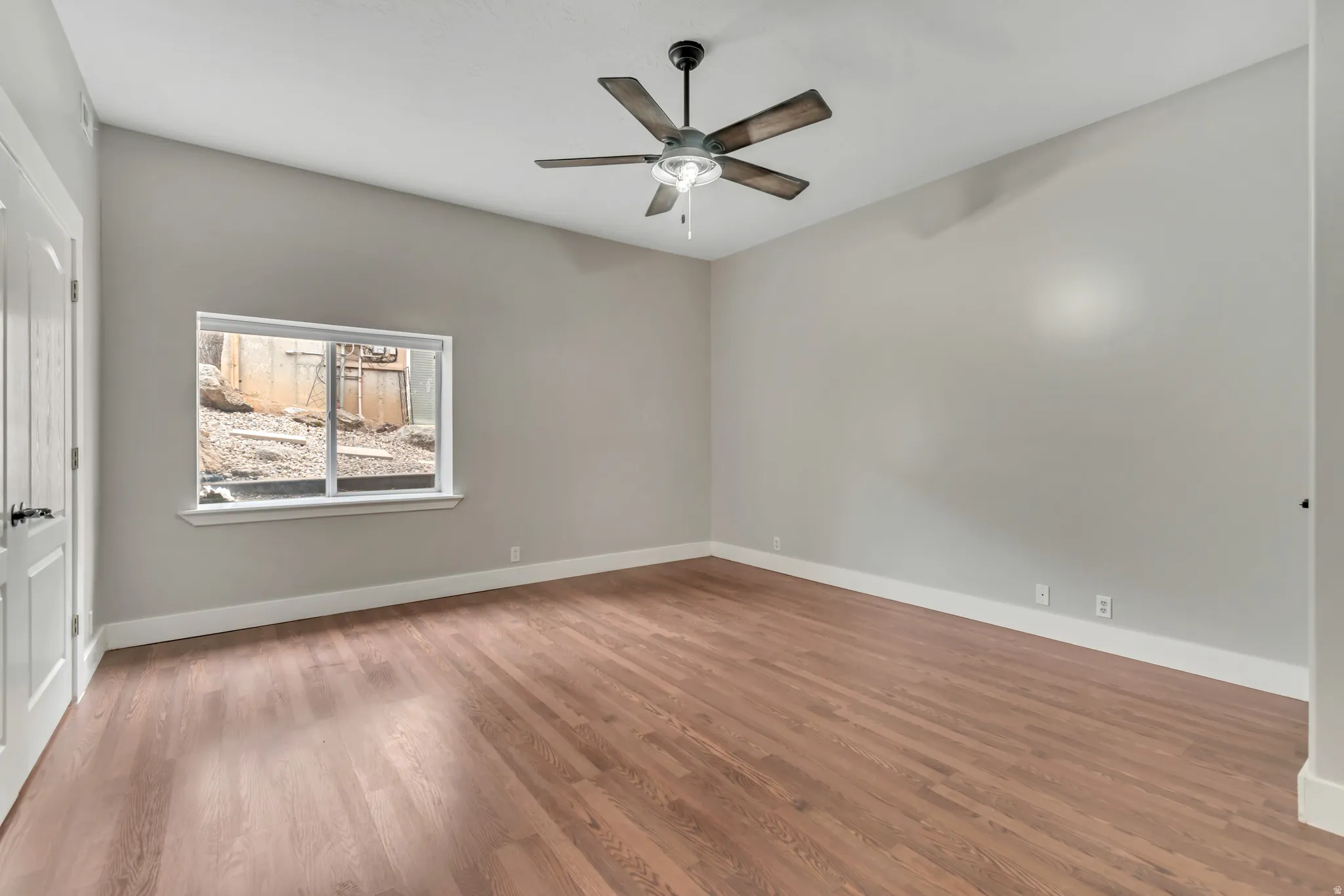 Empty room with light wood-type flooring and a ceiling fan
