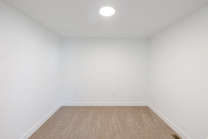 Unfurnished room featuring baseboards and light colored carpet