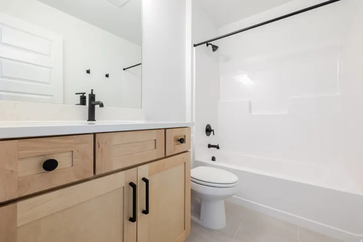 Bathroom featuring vanity,  shower combination, and light tile patterned flooring