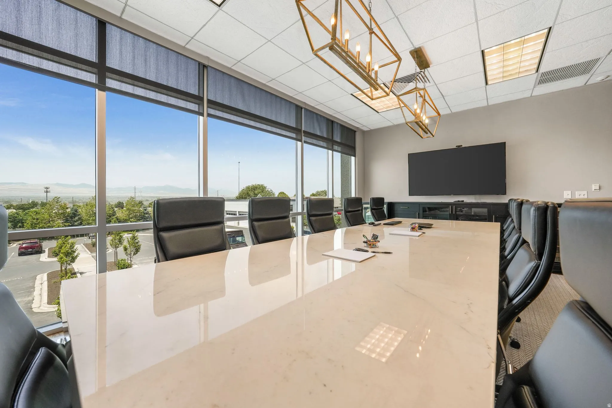 Office space with a mountain view, a wall of windows, and a paneled ceiling
