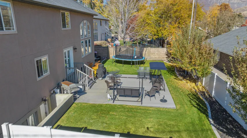Fenced backyard with a patio area and a trampoline