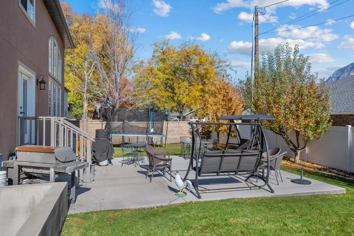 Fenced backyard with a patio area and a trampoline
