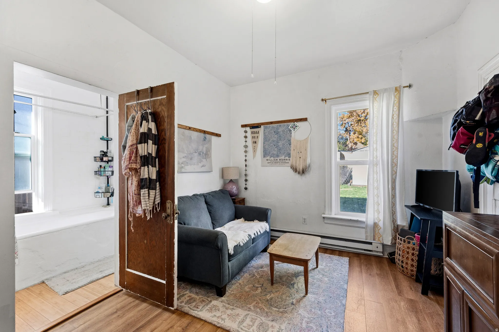 Living area featuring light wood-style flooring and baseboard heating