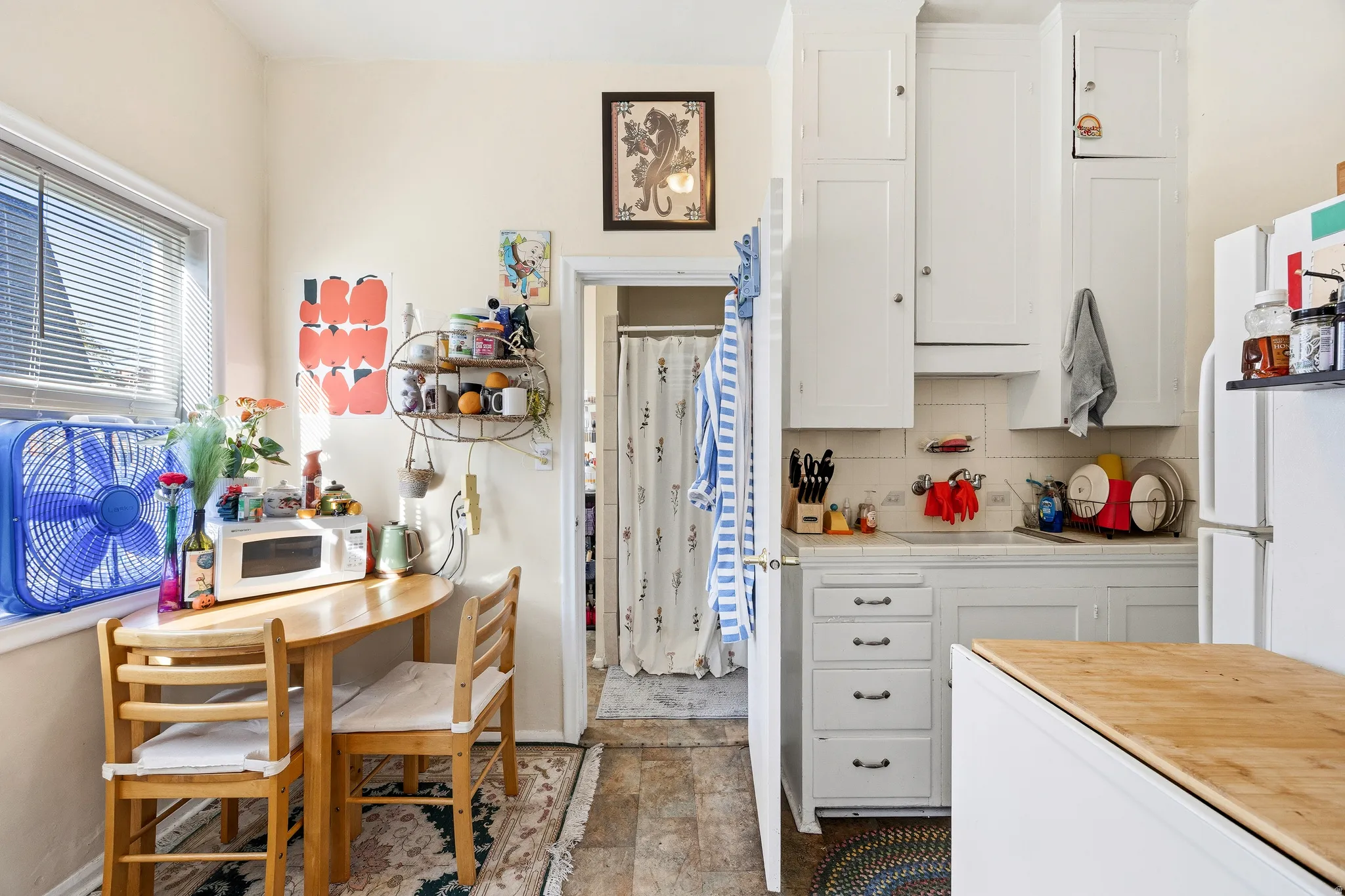 Kitchen featuring white cabinetry, decorative backsplash, tile counters, and white appliances