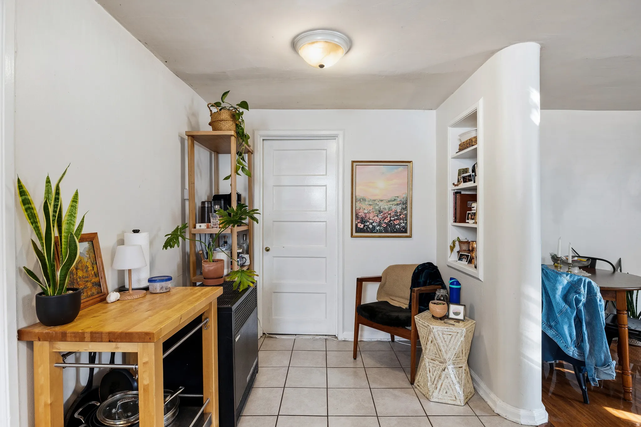 Sitting room with light tile patterned flooring and built in shelves