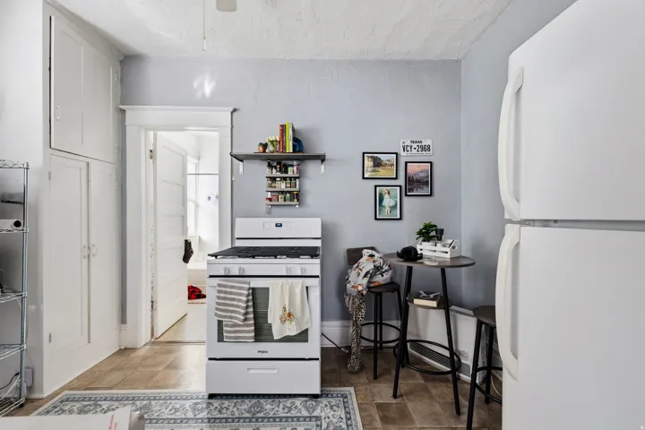 Kitchen with white appliances and open shelves