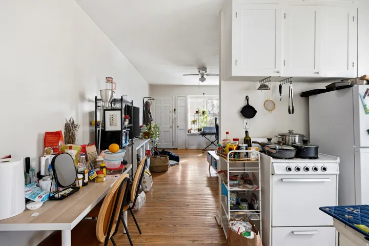 Kitchen featuring white appliances, light wood-style floors, white cabinetry, and ceiling fan