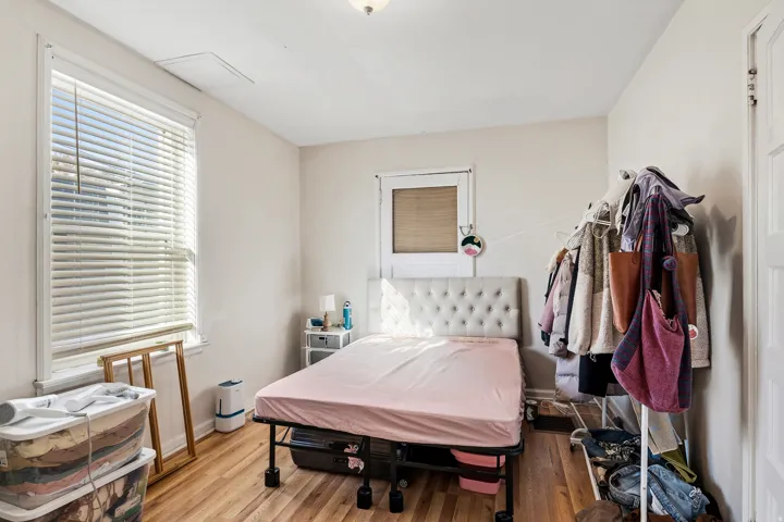 Bedroom with wood finished floors and baseboards