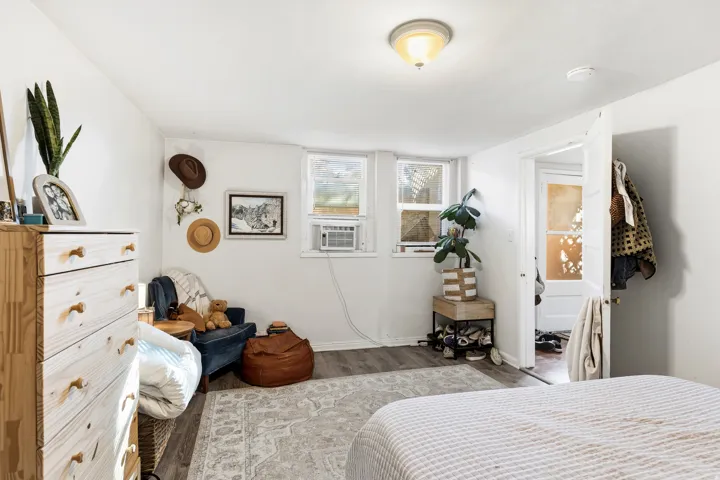 Bedroom with wood finished floors and cooling unit
