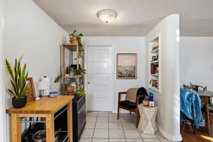 Sitting room with light tile patterned flooring and built in shelves