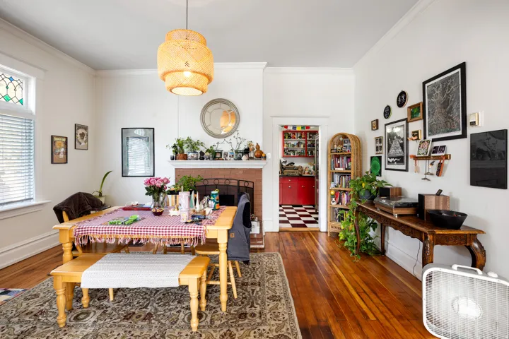 Dining area featuring ornamental molding, a brick fireplace, and dark wood-type flooring