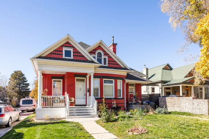 Victorian house featuring a front lawn, covered porch, and a chimney
