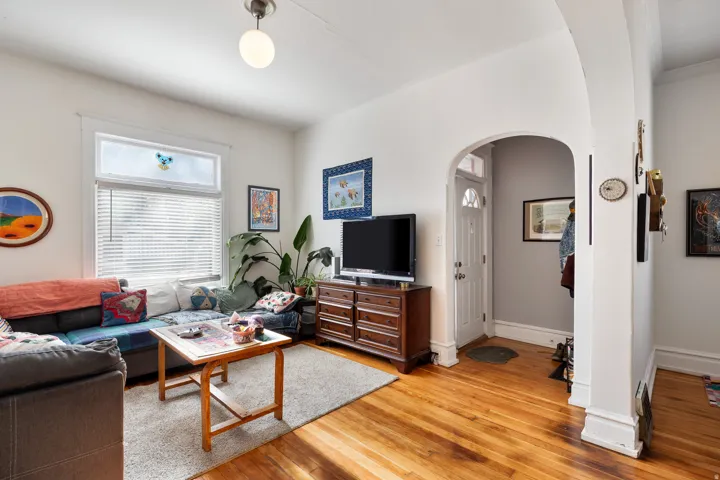 Living area featuring arched walkways and light wood finished floors