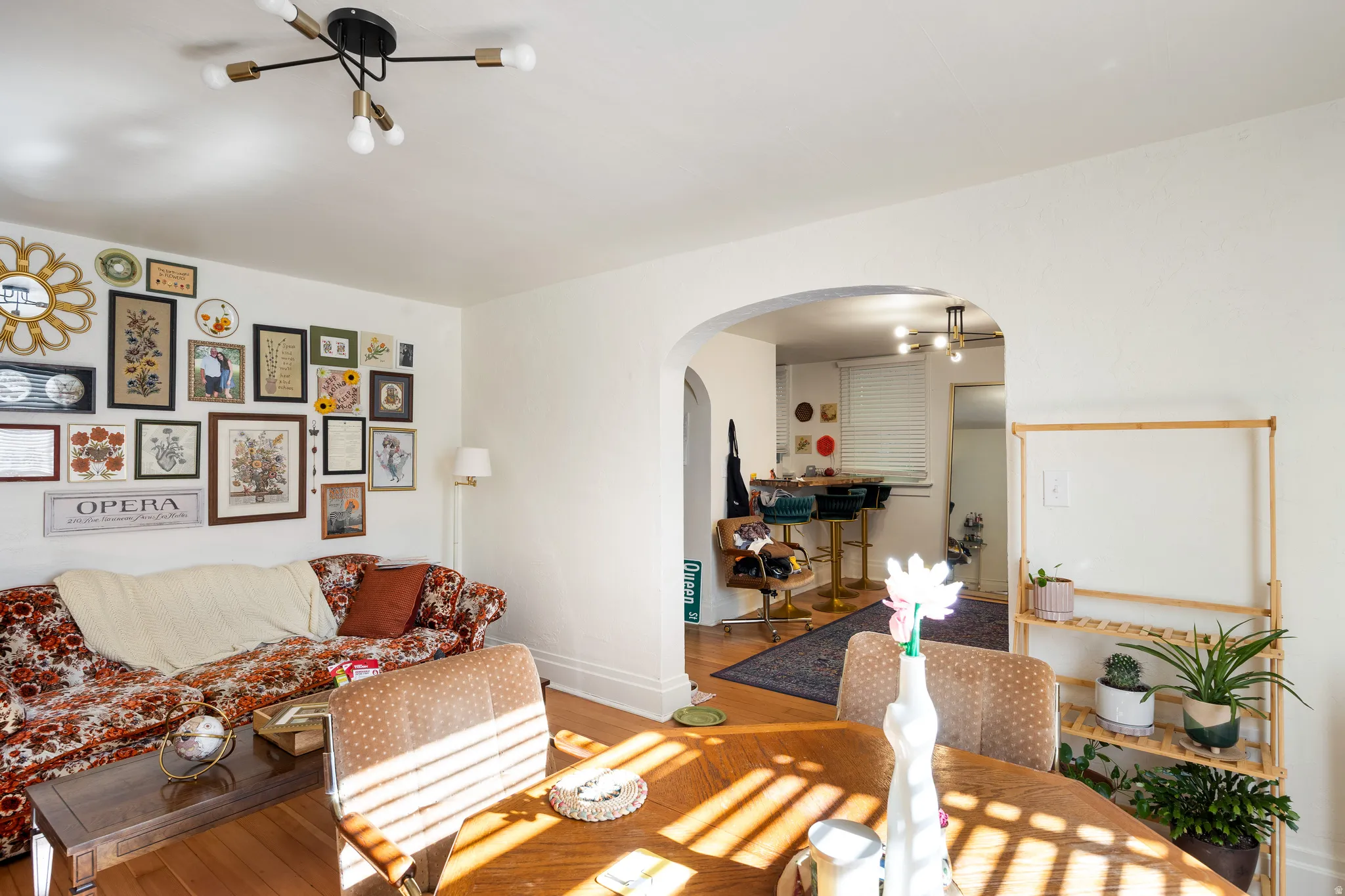 Living area featuring wood finished floors, arched walkways, and a chandelier