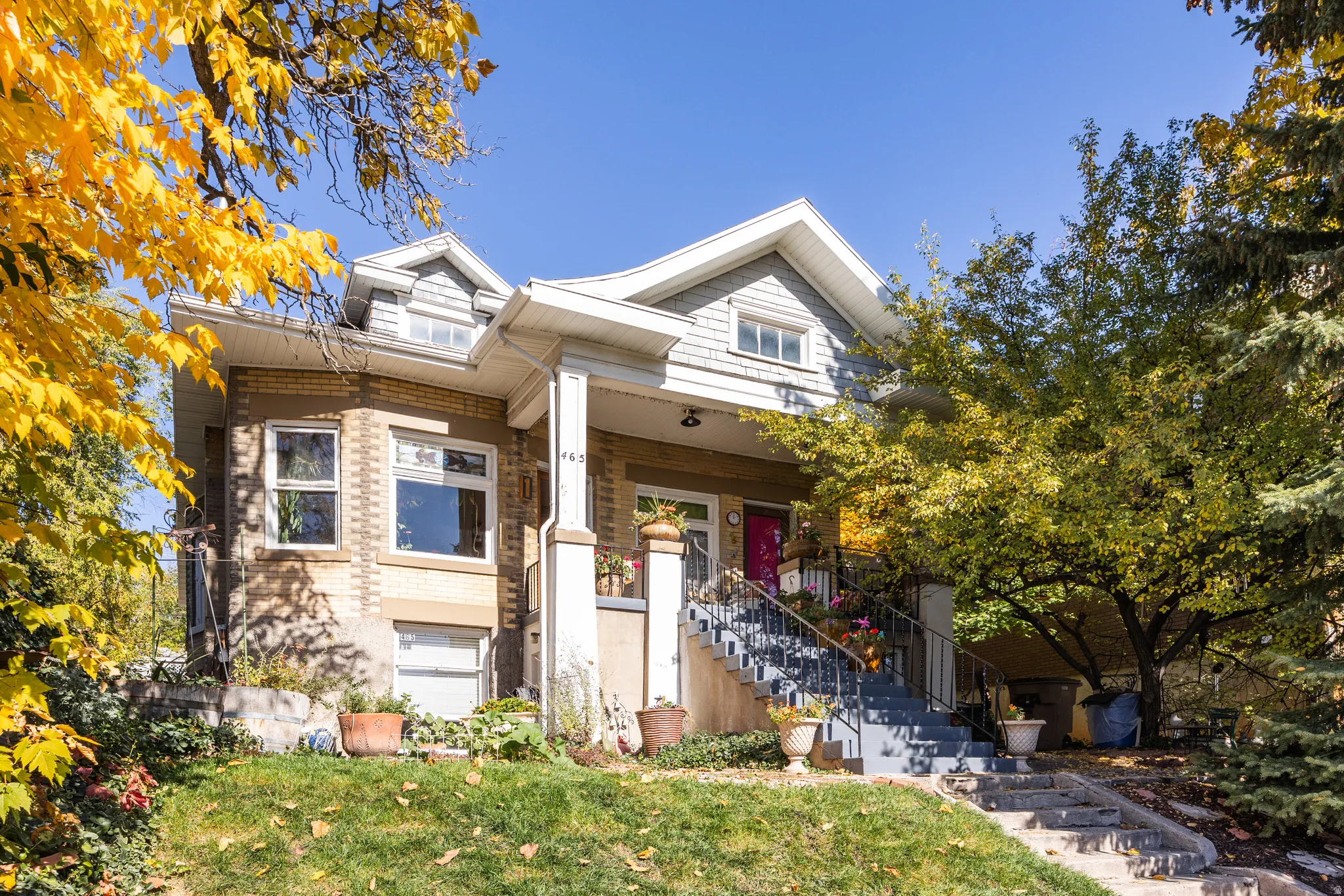 View of front of home featuring a front lawn, stairway, brick siding, and a porch