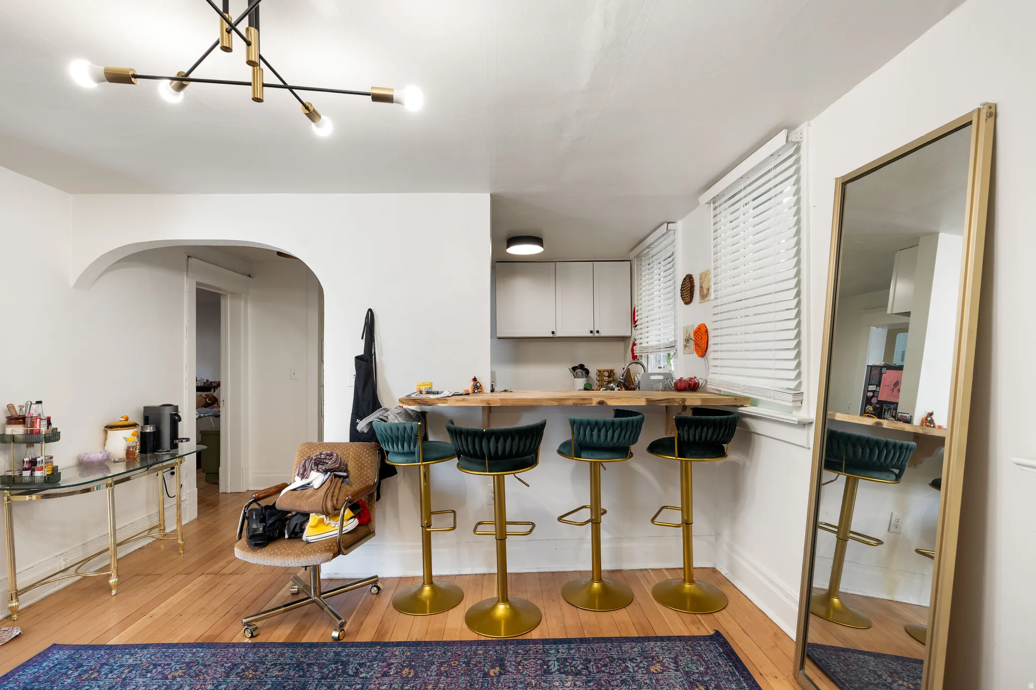 Kitchen featuring a kitchen bar, light wood-style floors, arched walkways, butcher block counters, and gray cabinetry