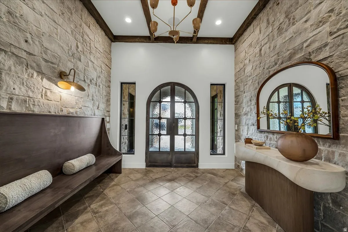 Foyer featuring french doors, an accent wall, and a high ceiling