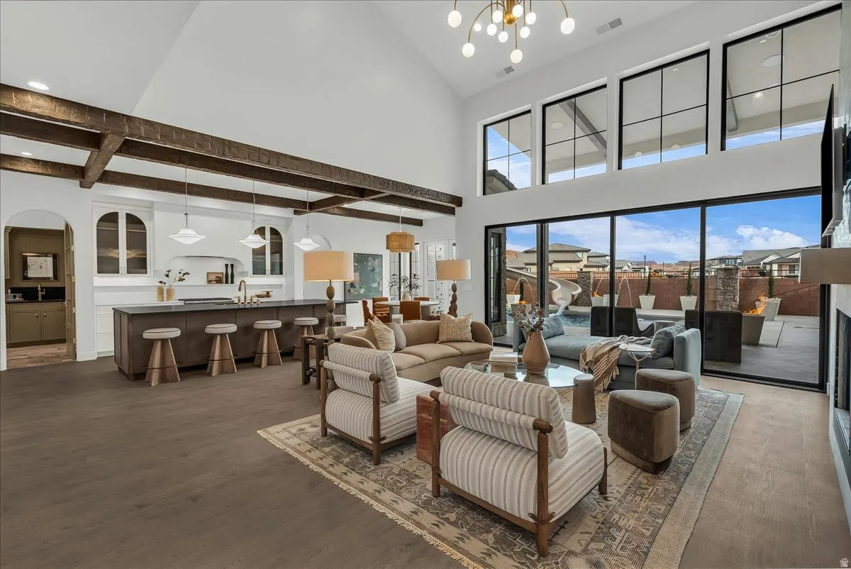 Living area with arched walkways, dark wood-type flooring, hanging lights, and Paulted ceiling