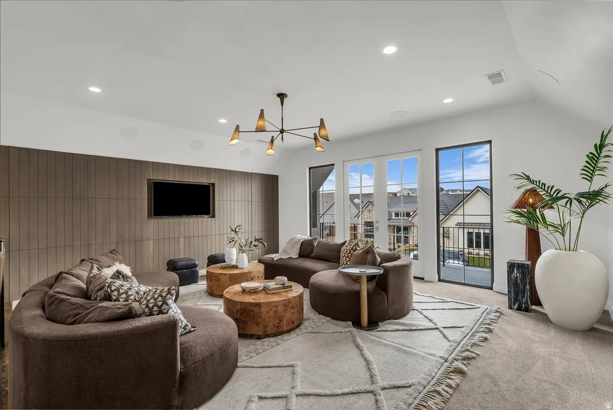 Carpeted living room with suspended lighting