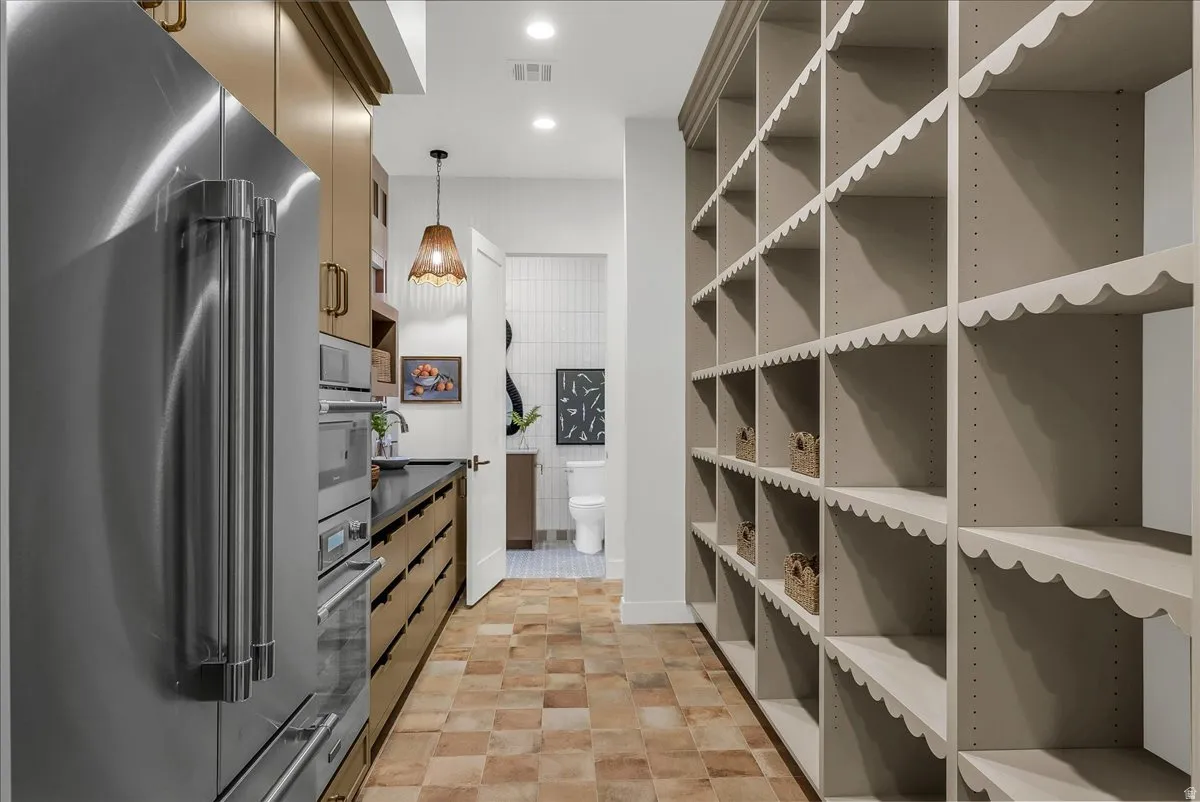 Scullery Kitchen featuring stainless steel appliances, pendant lighting, and dark countertops