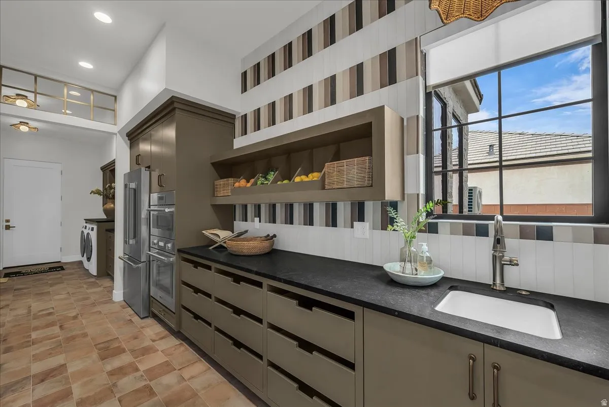 Scullery Kitchen with open shelves, stainless steel appliances, independent washer and dryer, recessed lighting, and dark stone countertops