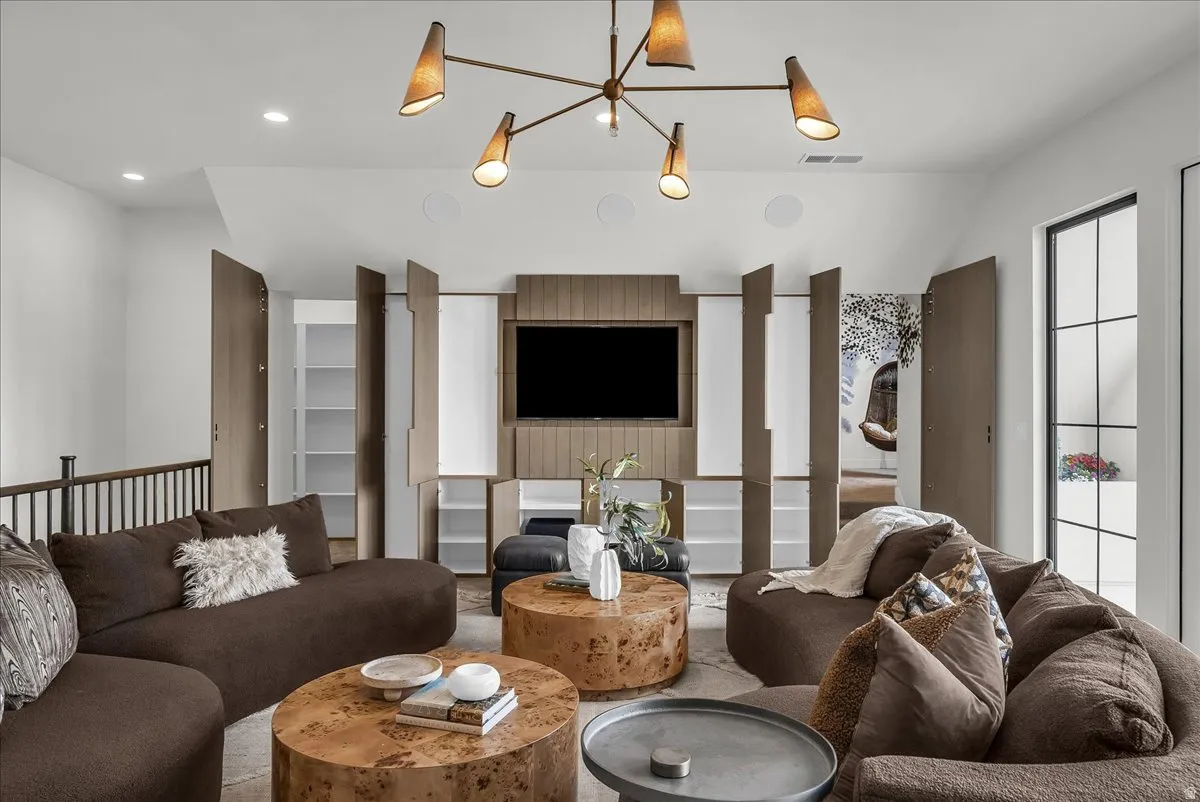 Living room with vaulted ceiling and suspended lighting