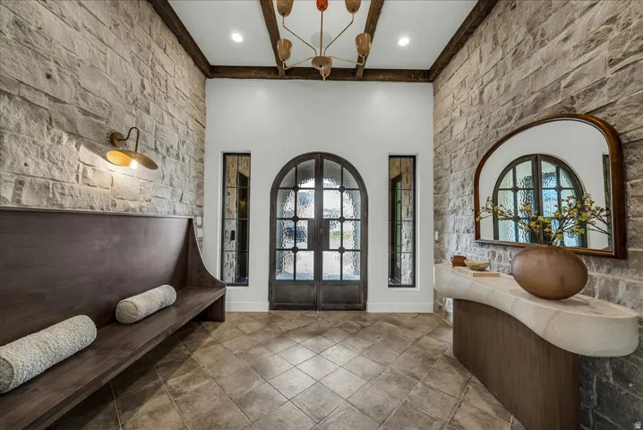 Foyer featuring french doors, an accent wall, and a high ceiling