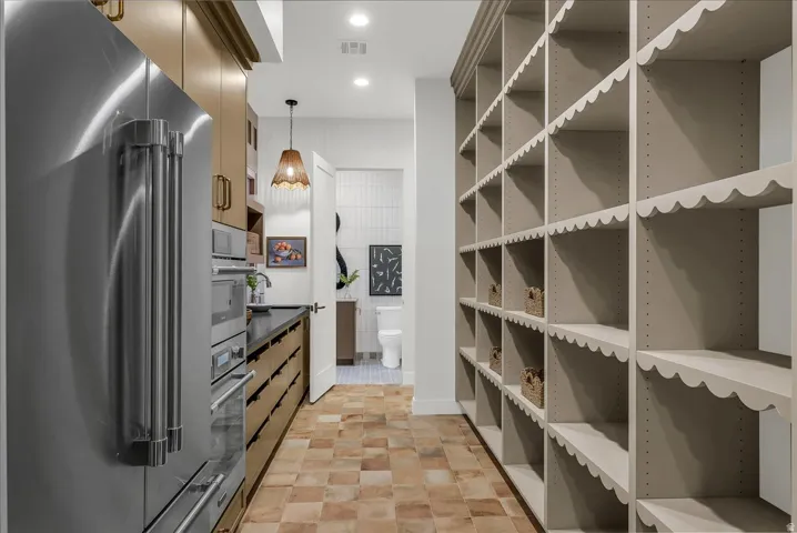 Scullery Kitchen featuring stainless steel appliances, pendant lighting, and dark countertops