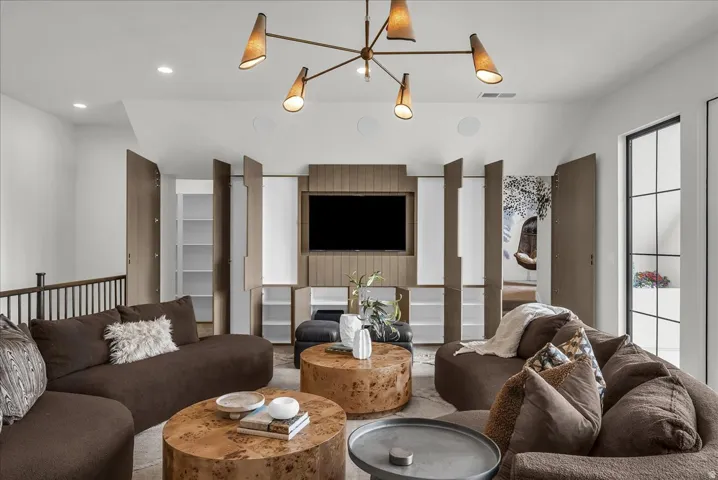 Living room with vaulted ceiling and suspended lighting