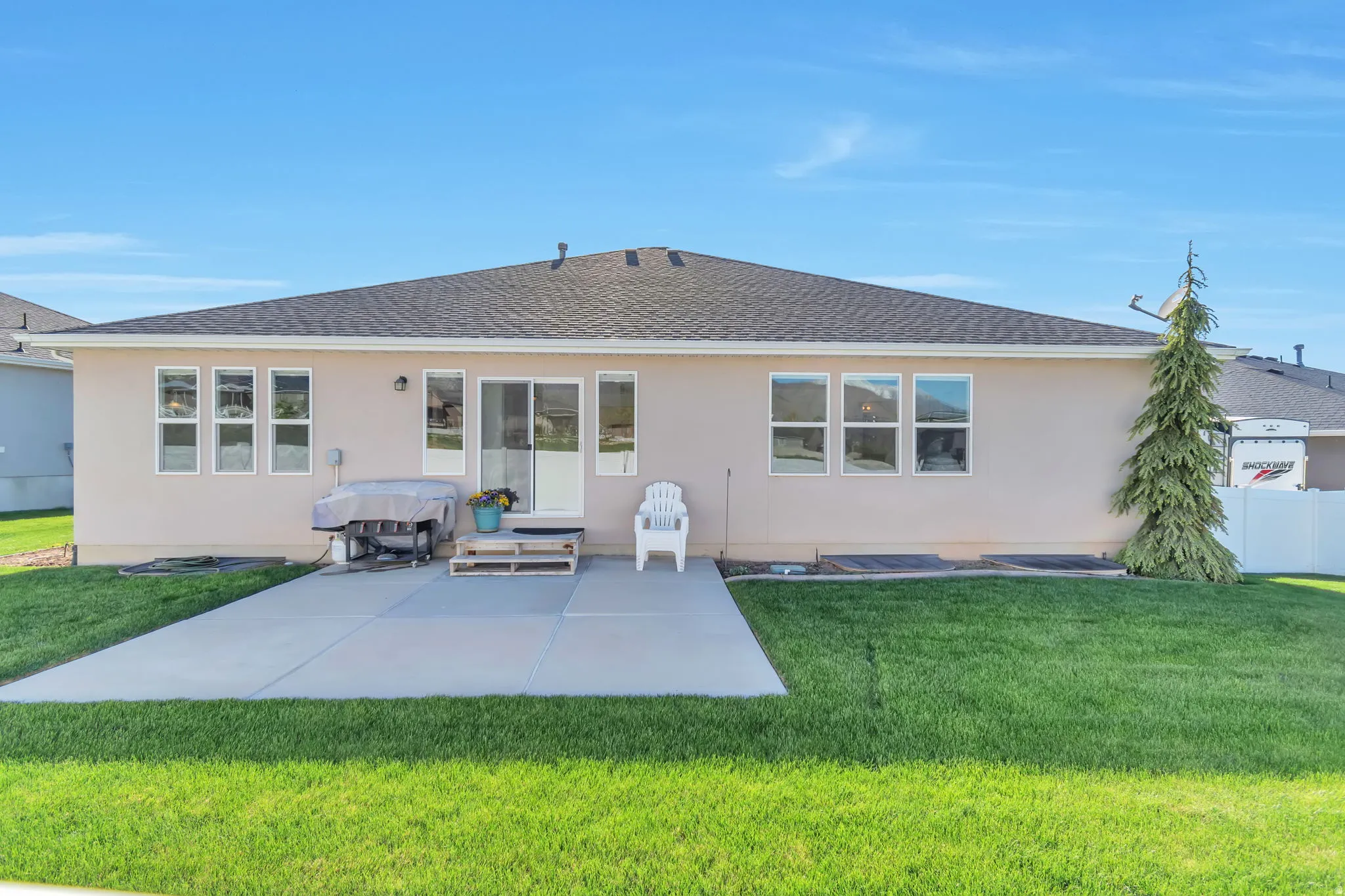 Rear view of property with a patio, stucco siding, and a shingled roof