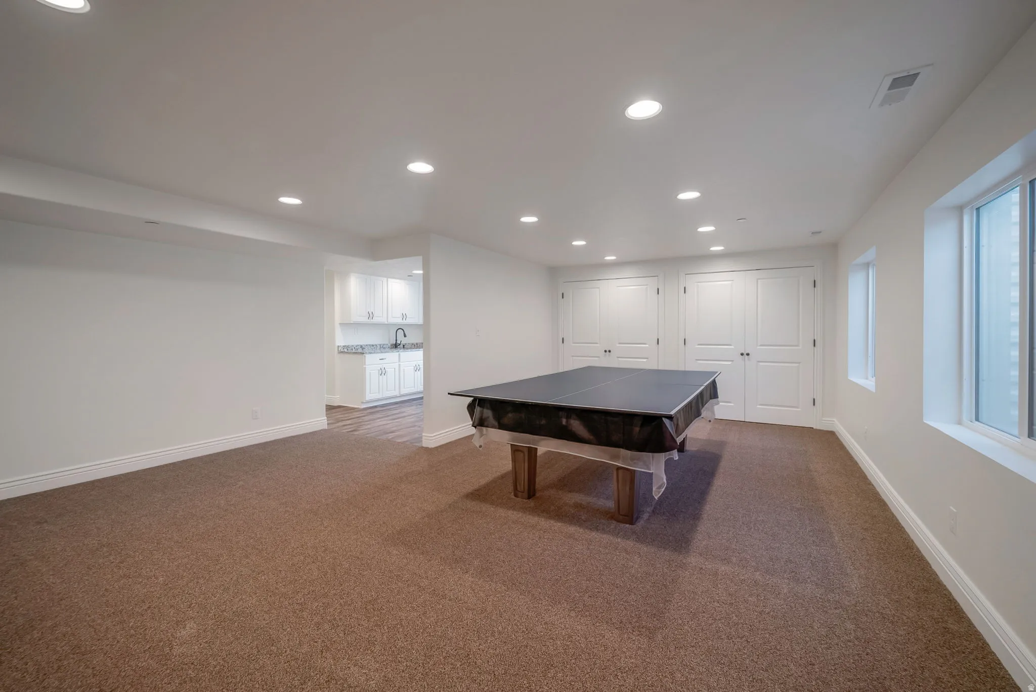 Recreation room featuring recessed lighting and dark carpet