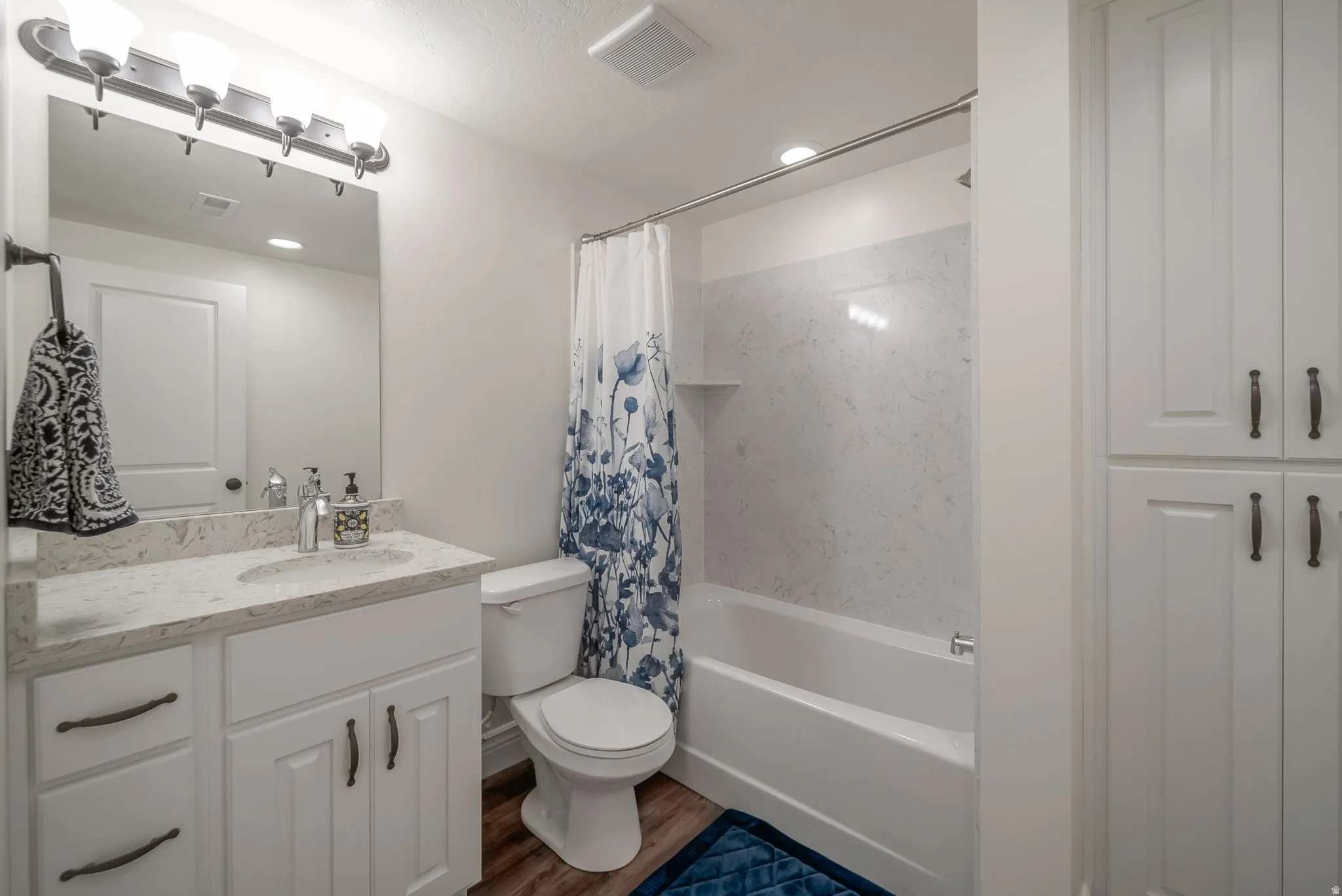 Bathroom with shower / bath combo, vanity, dark wood-style floors, and recessed lighting