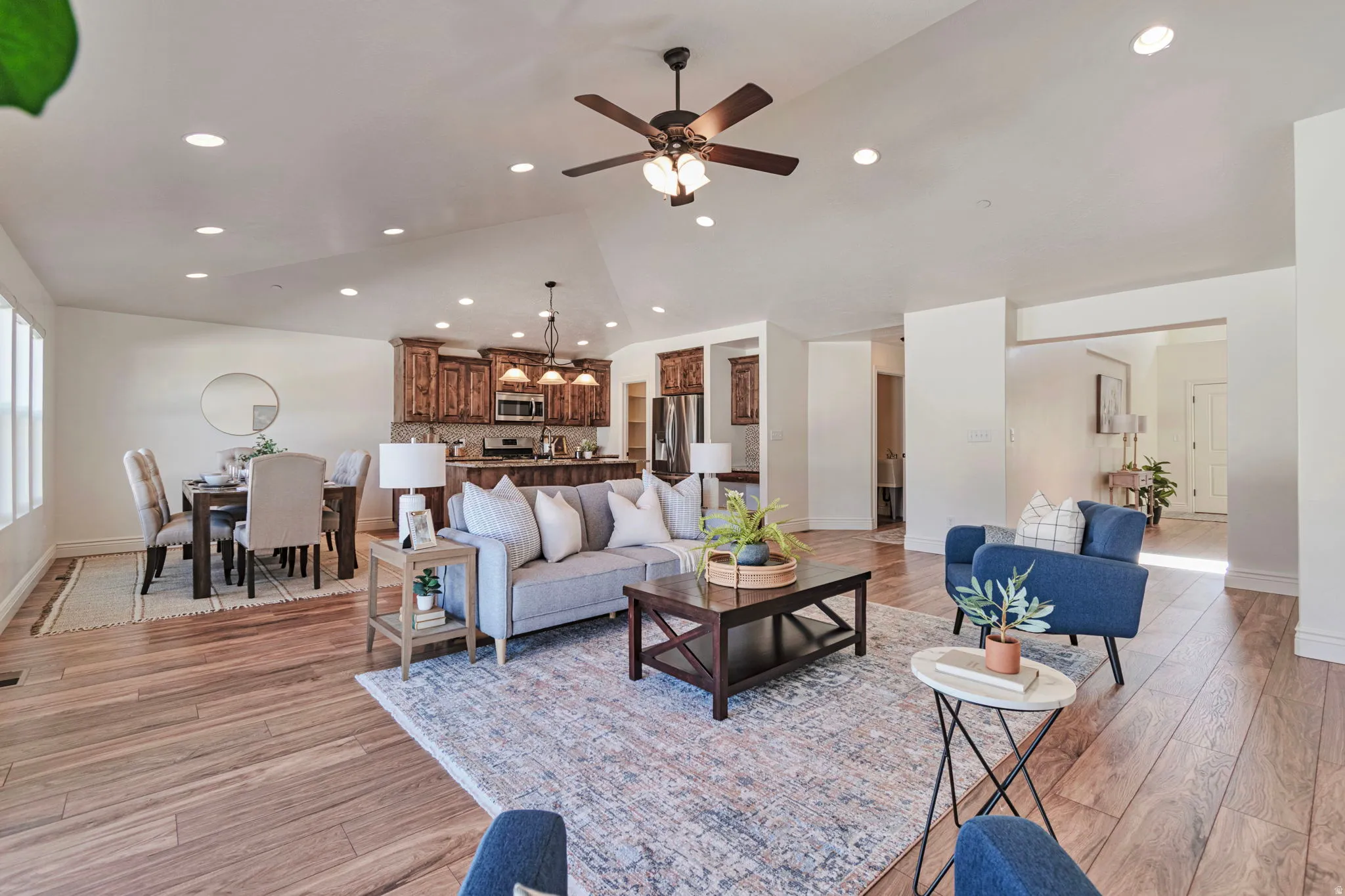 Living room featuring light wood-style flooring, a ceiling fan, and recessed lighting