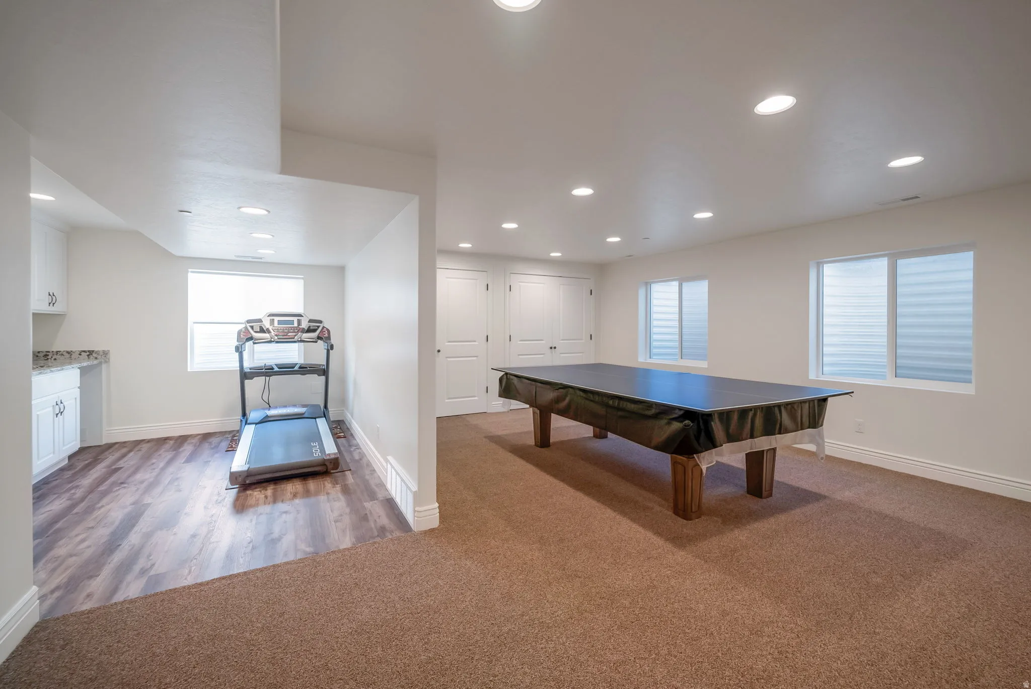 Rec room with dark carpet, recessed lighting, and dark wood-style floors