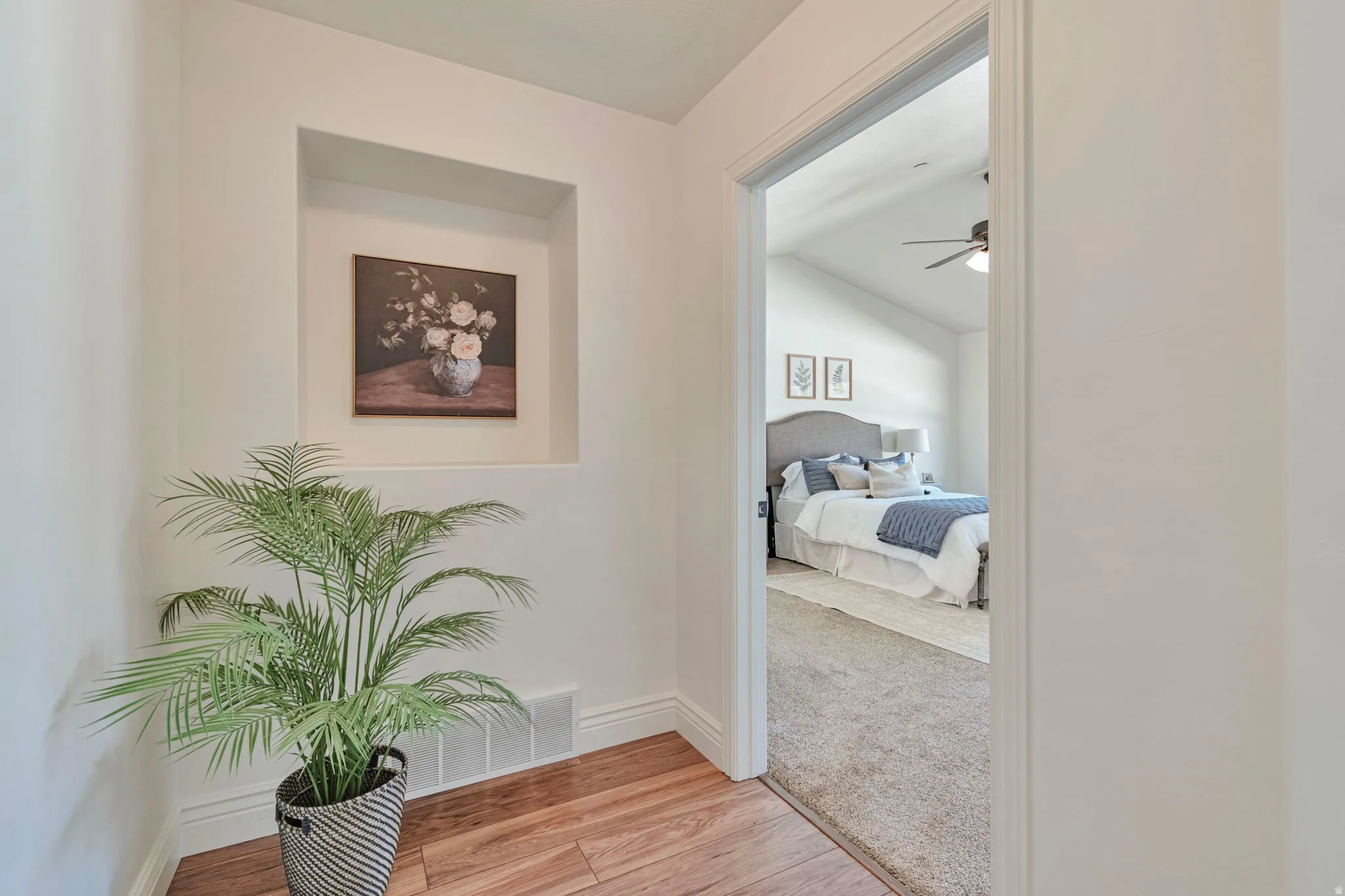 Hallway with light wood-style flooring and vaulted ceiling