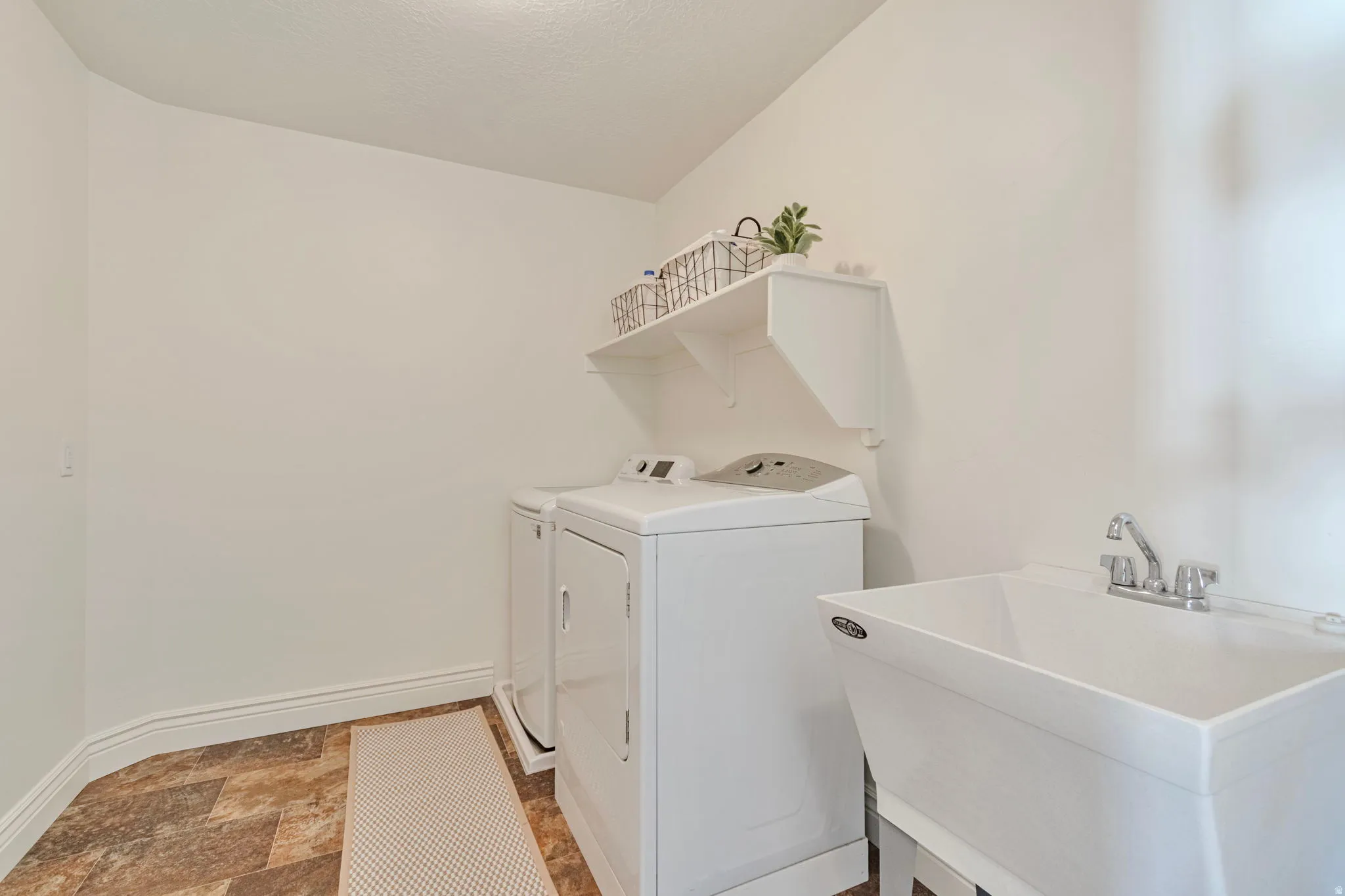 Laundry room featuring stone finish flooring and washer and dryer