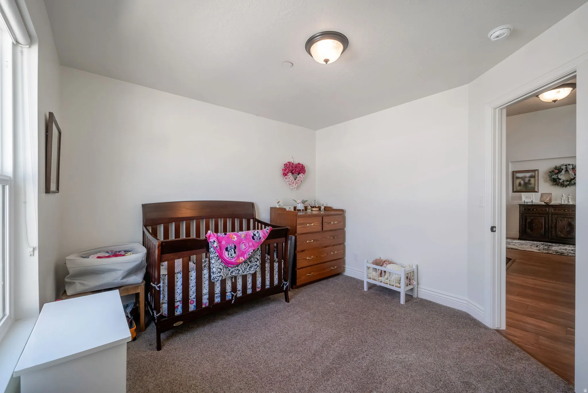 Bedroom with a nursery area and dark carpet