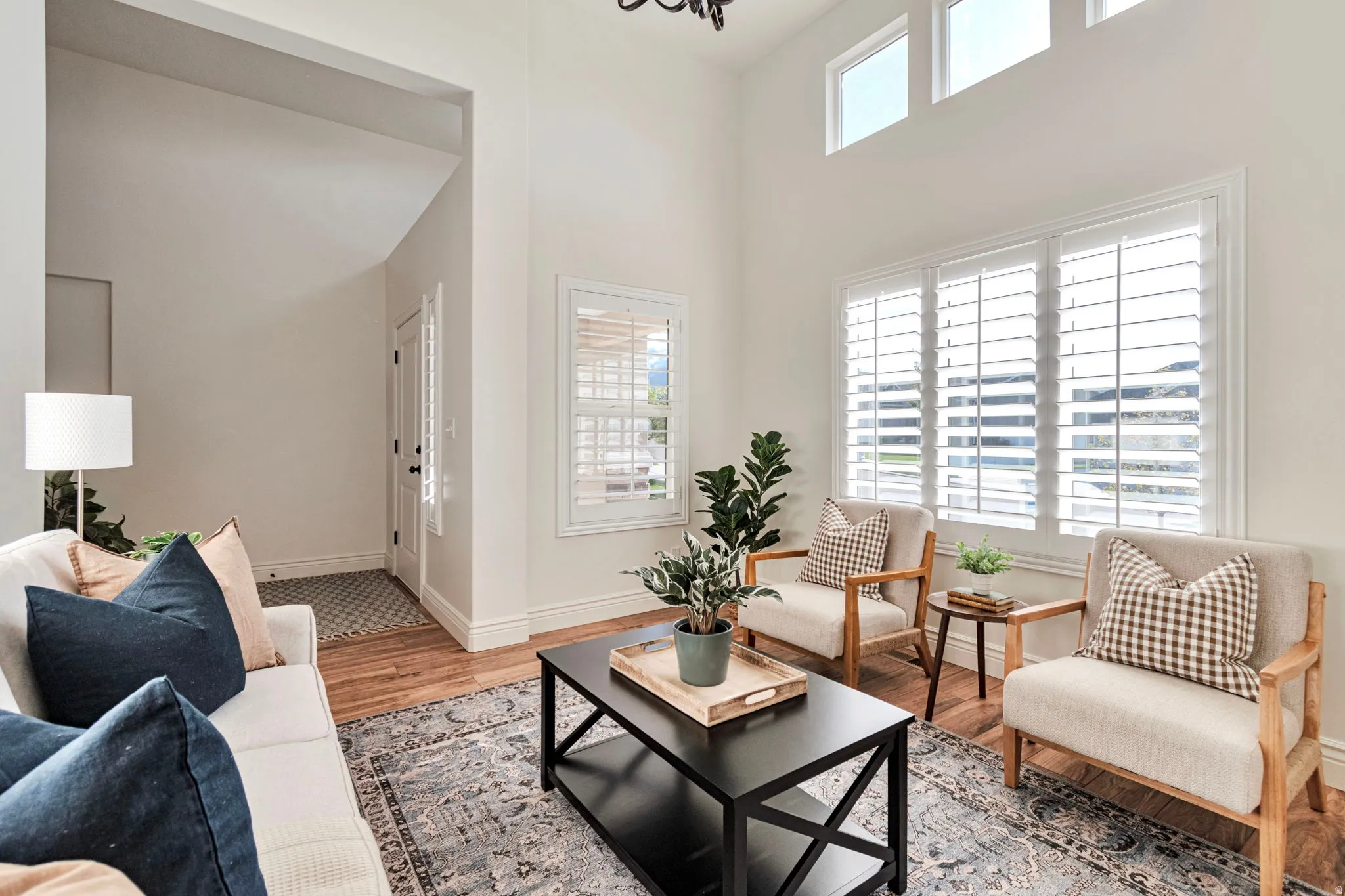 Living room featuring light wood finished floors and a high ceiling