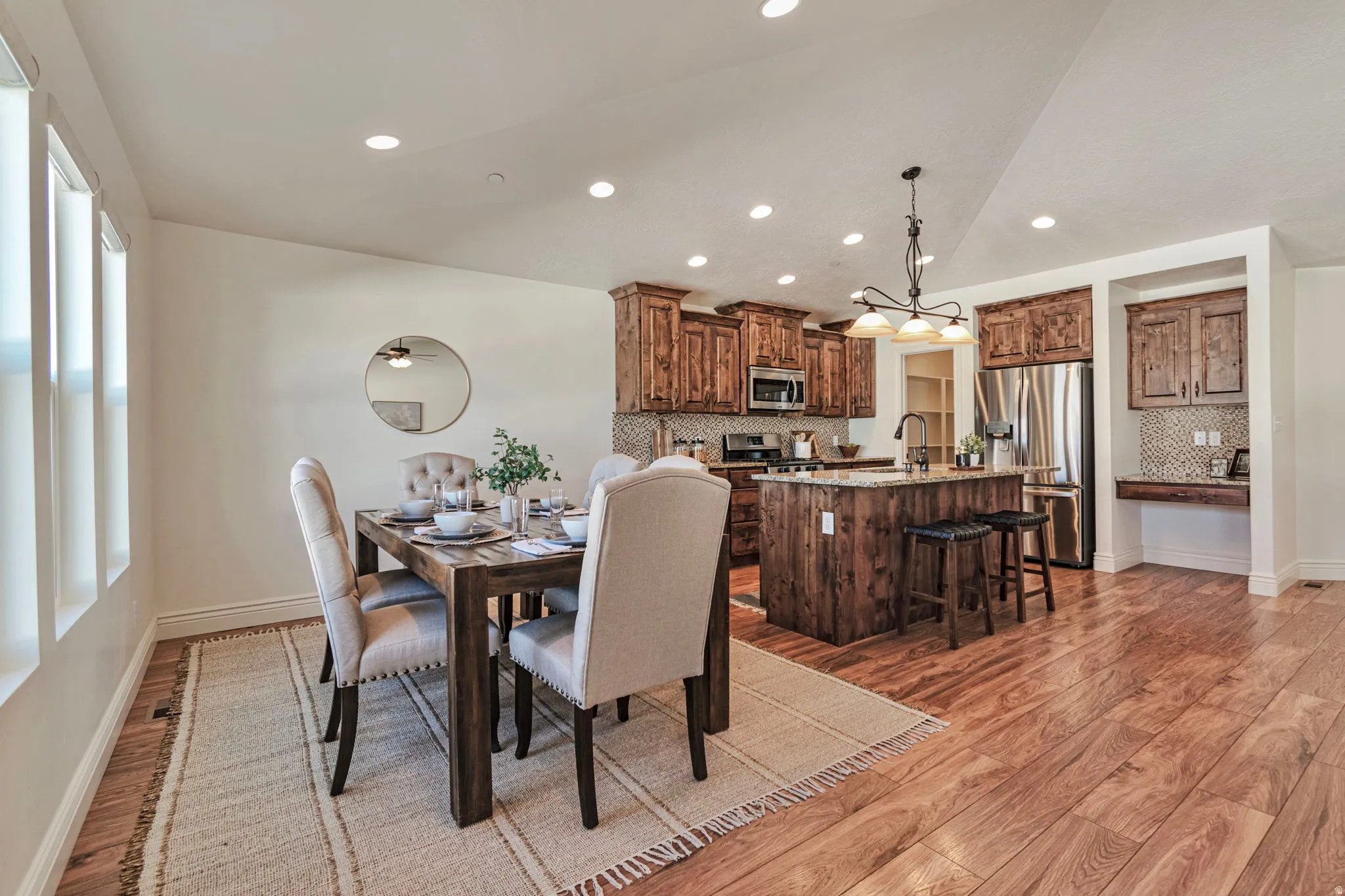 Dining room featuring light wood-style floors, vaulted ceiling, and recessed lighting