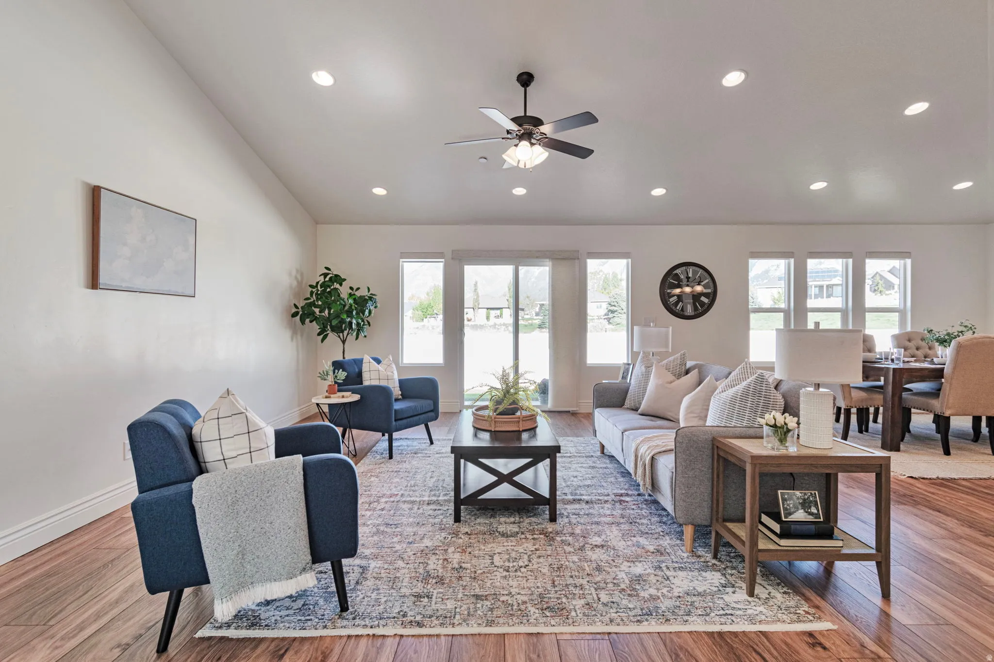 Living area featuring wood finished floors, ceiling fan, recessed lighting, and vaulted ceiling
