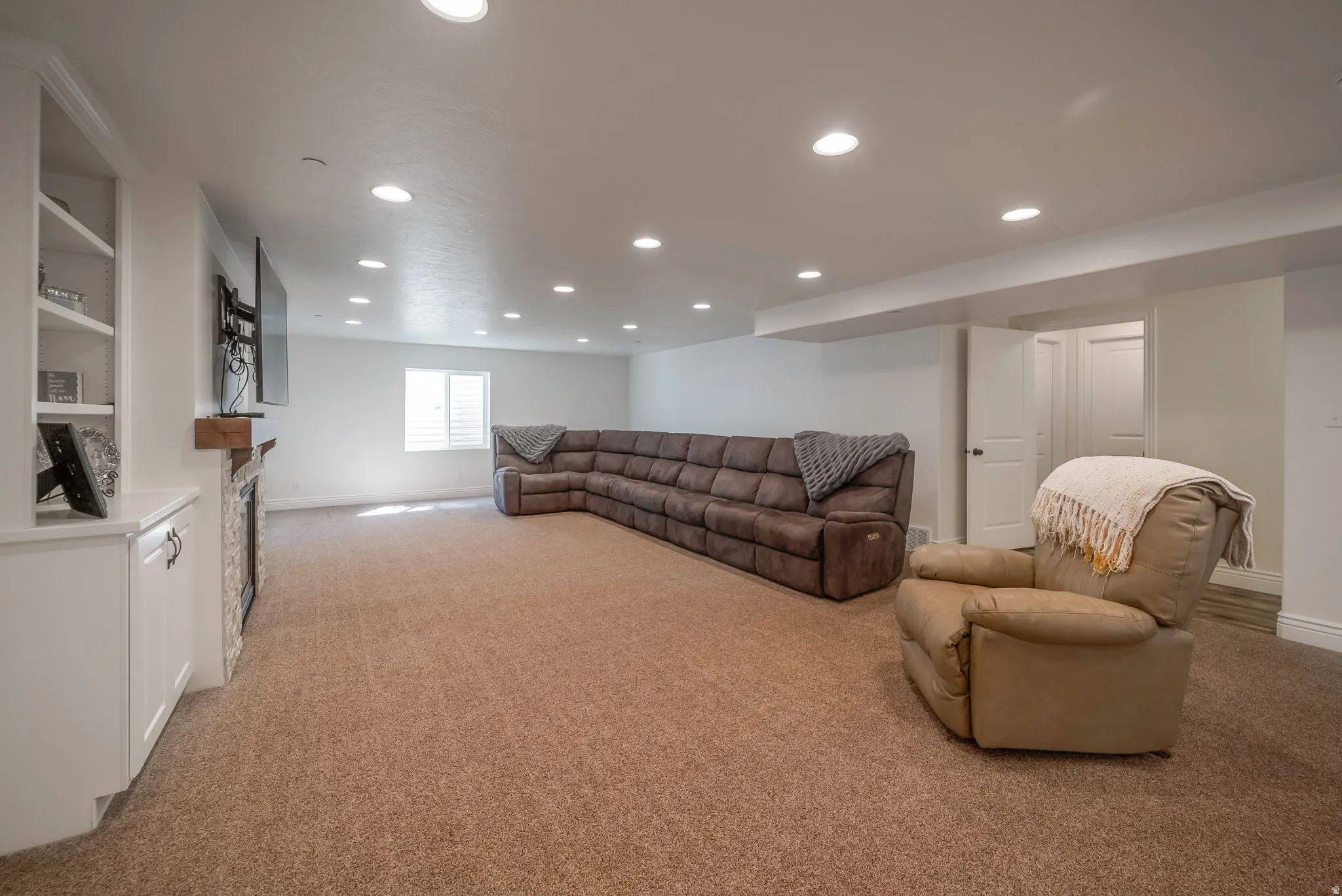 Living room featuring recessed lighting, light carpet, and a fireplace