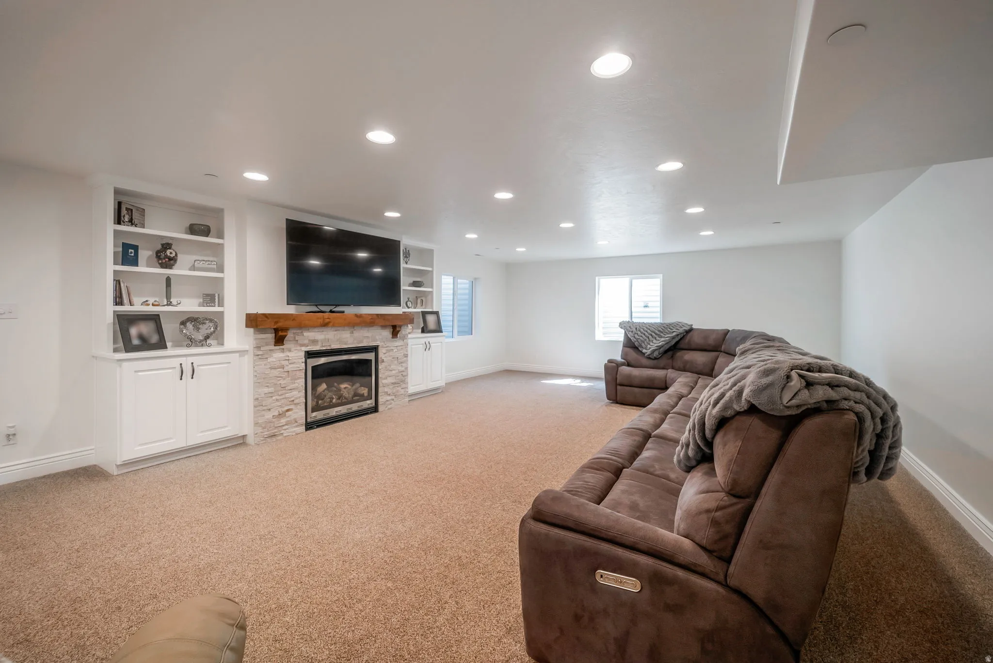 Living area with light carpet, recessed lighting, and a fireplace