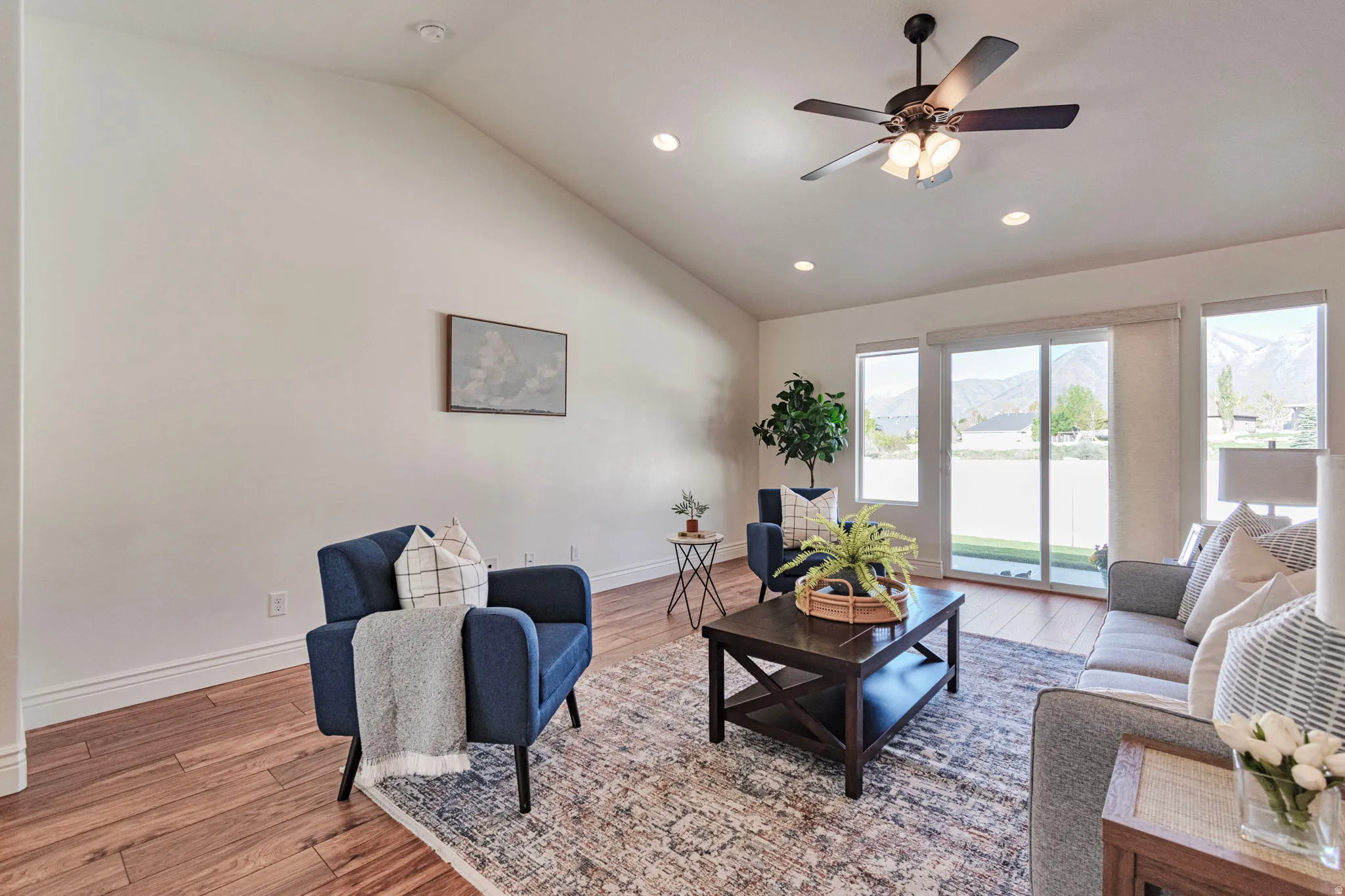Living room featuring light wood finished floors, a ceiling fan, lofted ceiling, and recessed lighting