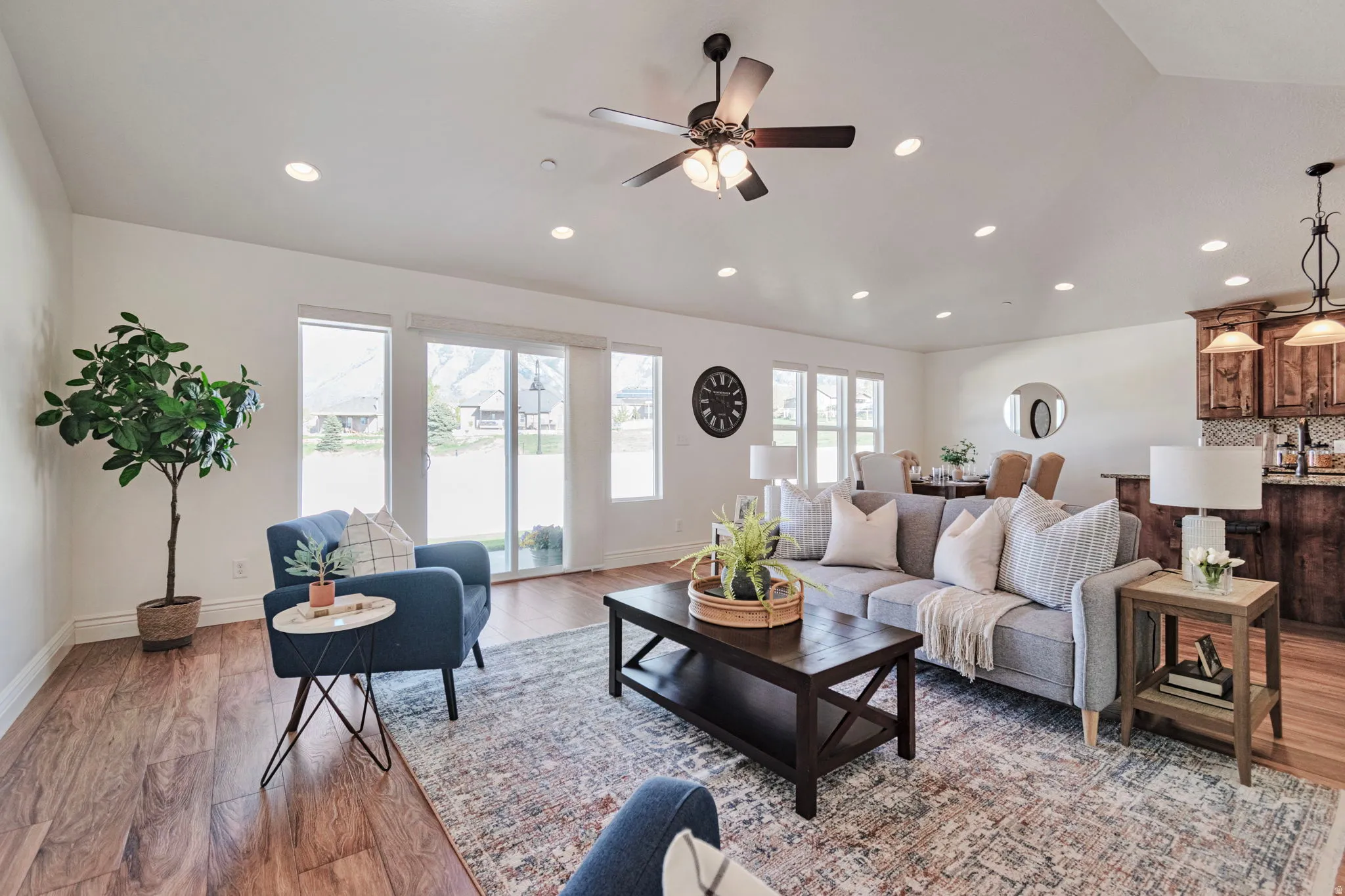 Living area featuring light wood finished floors, a ceiling fan, and recessed lighting