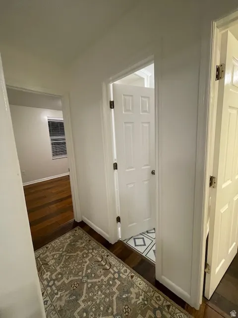 Hallway with dark wood-style flooring and baseboards