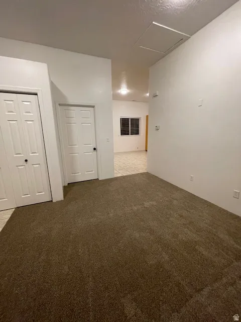 Unfurnished room with light colored carpet and a textured ceiling